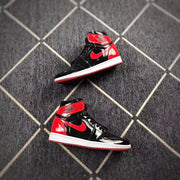 Two black and red high-top sneakers arranged on the floor in opposite directions.