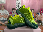 Three-quarter view highlighting the layered side panels, green upper, and textured outsole.