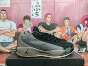 Side view of black and grey Jordan basketball sneakers displayed on a shoebox.