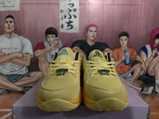 Front view of yellow basketball sneakers with lace-up uppers, dark navy tongue logos, and contrasting outsole accents.