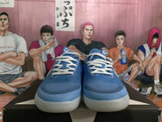 Front view of a pair of blue lace-up sneakers with white laces, textured uppers, and translucent off-white outsoles.