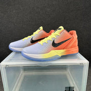 Three-quarter view of a pair of sunset-gradient basketball sneakers displayed on a clear stand.