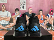 Rear view of black and silver Adidas basketball sneakers showing blue heel logos and padded collars.