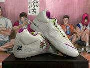Angled view showing the textured white uppers, purple side details, and lime-green accents.