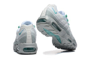 Rear and outsole views of white, grey, and green Nike Air Max 95 TT sneakers