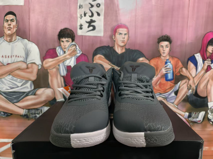Front view of dark gray and black basketball sneakers with laces, textured uppers and light-colored midsoles.