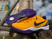 Gold Kobe 8 shoe shown with a view of the purple outsole