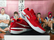 Angled view showing red mesh-style Nike basketball shoes with white Swoosh details and speckled soles