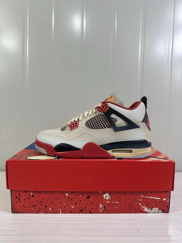 Side view of off-white Jordan Air Jordan 4 Retro sneakers with red and dark navy accents on a red shoebox.