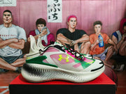 Side profile showing the butter-white upper, black laces, colored side panels and textured outsole.