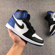 Handheld side view highlighting the black toe and overlays, perforated white toe box, blue heel panel, and blue outsole.