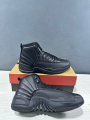 Pair of black high-top Jordan sneakers shown from the side with a shoebox in the background.