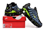 Nike Shox TL sneakers in black, blue, and volt displayed with a Nike shoe box; the box label shows the model and size details.