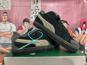 Pair of black Puma sneakers showing the taupe side stripes and grey accents
