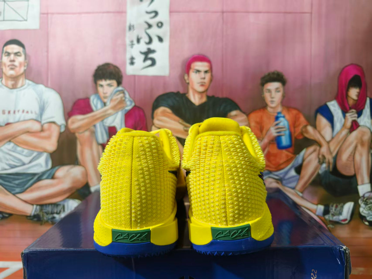 Rear view of yellow Nike LeBron basketball shoes with blue outsoles.