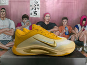 Side profile showing the gold Swoosh, layered upper, and sculpted sole of a yellow Nike basketball shoe.