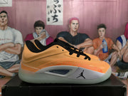 Side view of an orange Jordan sneaker showing layered panels, black collar details, Jumpman branding and a light gray midsole.