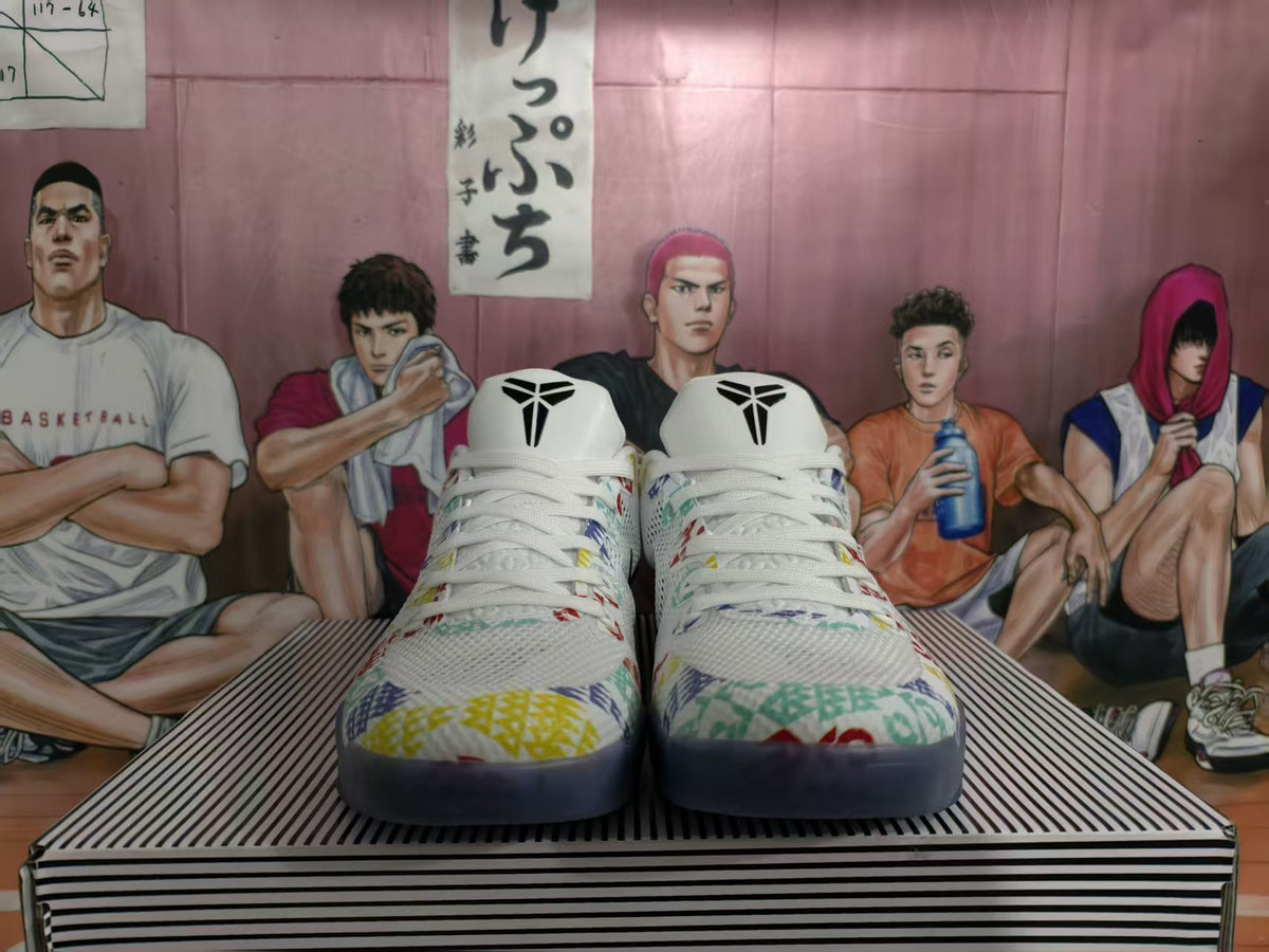 Front view of white basketball shoes with multicolor graphics, black tongue logos and dark blue outsoles.