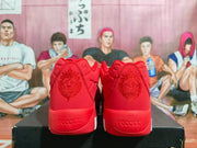 Rear view of the red sneakers showing decorative heel graphics and embossed “reactx” lettering.