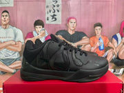 Side profile of a black basketball sneaker showing the layered upper, textured side detail and flat rubber outsole.
