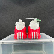 Rear view of the red and white sneakers showing the white heel panels, pull tabs, and vertical outsole details.