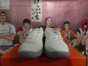 Front view of white and grey lace-up Nike basketball shoes with perforated details.