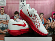 White and red Nike basketball shoes shown in a side view.