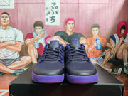 Front view of black and purple Nike basketball sneakers displayed on a box.