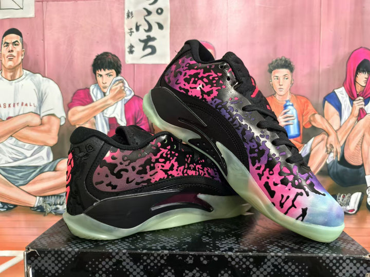 Pair of Jordan XXXVIII basketball shoes with black, pink, purple, and blue splatter-pattern uppers and translucent outsoles
