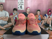 Front view of pink Nike basketball shoes with cream-patterned toes and navy outsoles