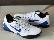 Close three-quarter view of the Nike Kobe 9 sneakers with white laces, blue accents and Kobe branding.