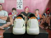 Rear view of the beige Jordan sneaker pair showing white heel panels, black Jumpman logos, and padded collars.