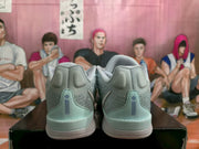 Rear view showing padded heel sections, pale blue heel overlays, and textured white outsoles.