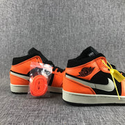 Pair of orange and black sneakers displayed with an additional orange lace set.