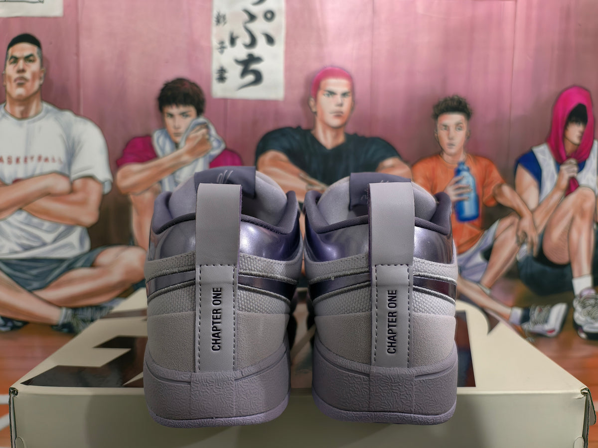 Rear view of a purple and gray pair of low-top sneakers with “CHAPTER ONE” printed on the heel tabs.