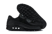 Black Nike Air Max 90 sneakers shown from the side and outsole.