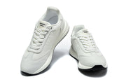 Pair of white lace-up sneakers viewed from the front, with Hermès Paris branding visible on the tongues.