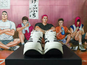 Front view of white adidas shoes with black stripe details and sculpted soles