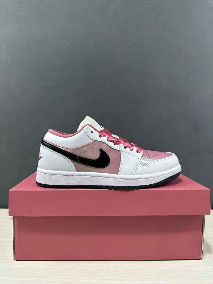 Side profile of a pink and white low-top sneaker with black side branding on a pink shoebox.