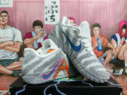 Pair of grey and white basketball shoes displayed at an angle, showing blue and pink-orange Swoosh accents.