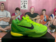 Side view showing the textured green upper, black swoosh, sculpted outsole and yellow midsole accent.
