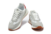 Front and angled views of grey and white lace-up sneakers with blue details and gum-colored outsoles.