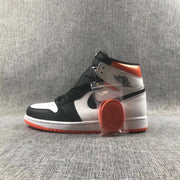 Side view of the sneaker pair with an orange lace set in a clear package.