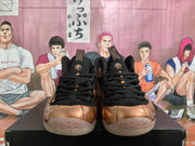 Front view of the pair showing black laces and tongue panels, bronze toe sections, orange accents, and translucent outsoles.
