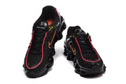 Front views of black Nike Shox TL sneakers with pink trim and orange accents