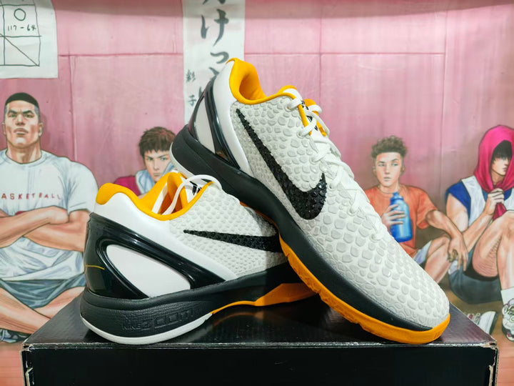 Pair of white, black, and gold Nike basketball sneakers displayed on a black shoe box.