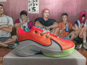 Side view of a red and white Nike sneaker with teal trim, a visible swoosh and a translucent green outsole.