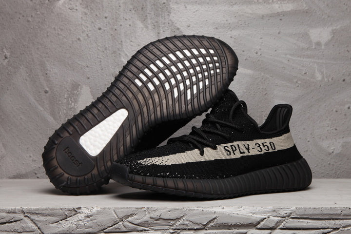 Side view of black Yeezy 350 V2 sneakers with a light stripe, SPLY-350 lettering and ribbed sole.