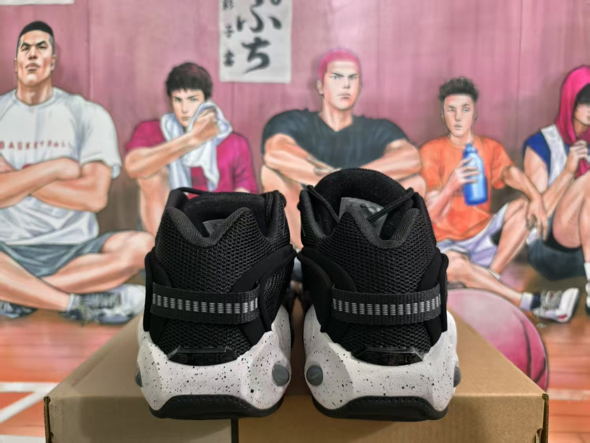 Rear view of black Nike sneakers with textured uppers, heel straps, and speckled white midsoles.