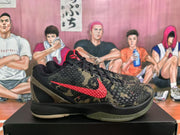 Side view of a Nike Kobe camouflage sneaker showing the red Nike Swoosh, textured upper and black midsole.